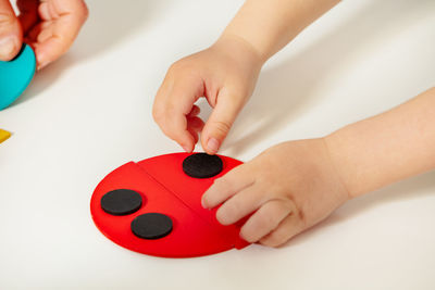 Cropped hands of woman holding toy against white background