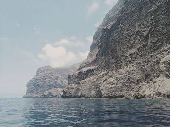 Scenic view of sea and mountains against sky