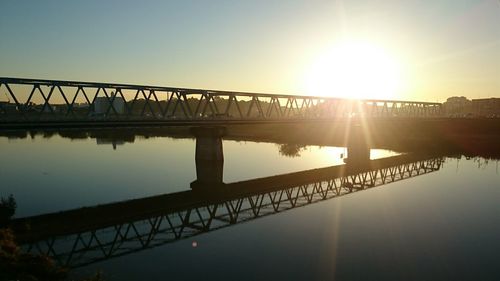 Bridge over river at sunset