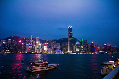 View of boats moored in river at night