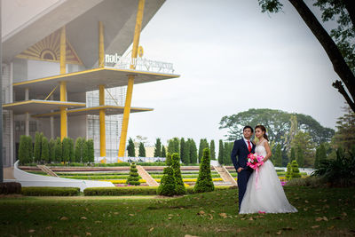 Portrait of bride and groom standing in park