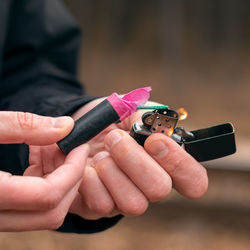 Close-up of man igniting firecracker outdoors