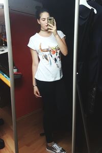 Young woman standing against wall