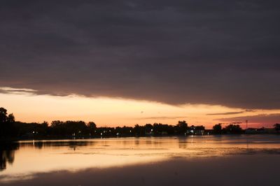 Scenic view of sea against cloudy sky at sunset