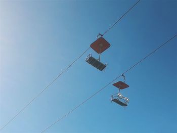 Low angle view of overhead cable against clear blue sky