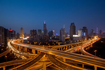 High angle view of illuminated city street and buildings at night