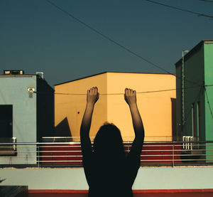 Rear view of silhouette woman standing against clear sky