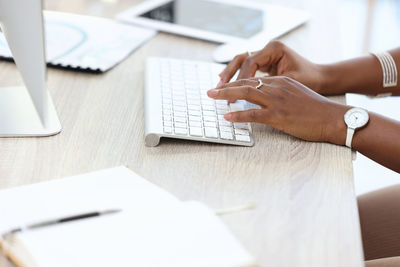 Cropped hands of man using laptop on table