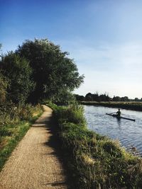 Footpath by river against sky