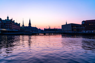 View of buildings at waterfront during sunset