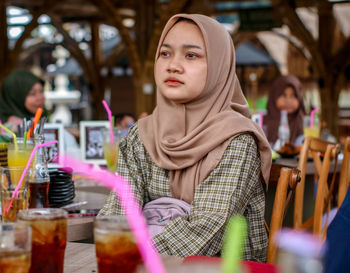 Portrait of smiling young woman sitting at amusement park