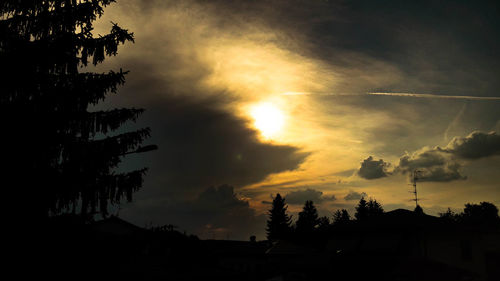 Low angle view of silhouette trees against dramatic sky