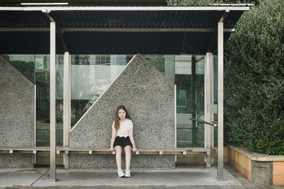 Portrait of woman standing against built structure