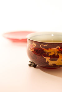 Close-up of tea cup on table against white background