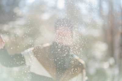 Portrait of woman seen through glass window