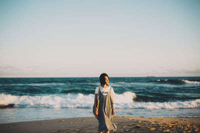 Man standing at beach against sky