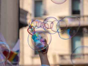 Midsection of man holding bubbles in glass