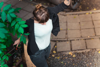 Rear view of woman standing with leaves