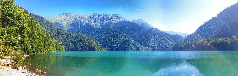 Scenic view of lake and mountains against blue sky