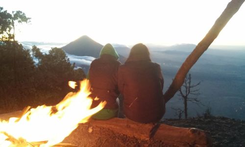 Rear view of a couple overlooking calm sea