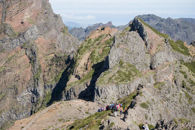 People on rocks against mountains