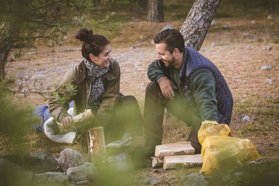 Happy couple with firewood in forest