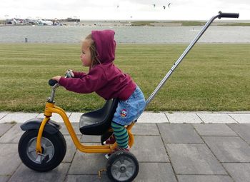 High angle view of boy playing with push scooter on footpath