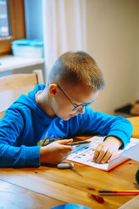 Side view of boy learning at home