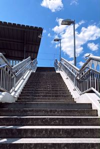 Low angle view of staircase amidst buildings against sky