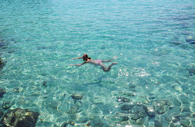 High angle view of woman swimming in sea at minorca island