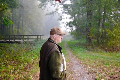 Profile view of senior man standing in forest