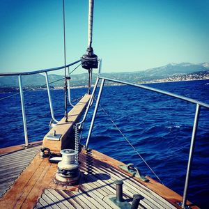 Ship sailing in sea against clear blue sky