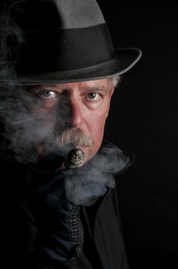 Close-up portrait of man against black background