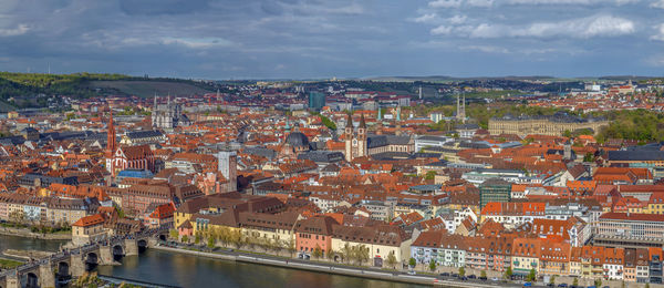 High angle view of river amidst buildings in town against sky