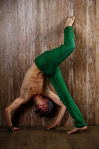 Full length of happy young man sitting on floor