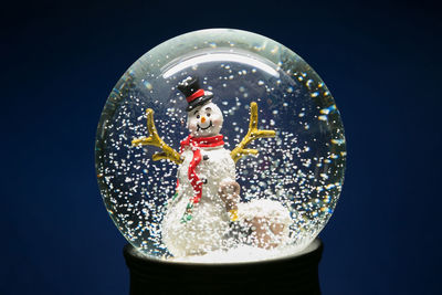 Close-up of snow globe against blue background