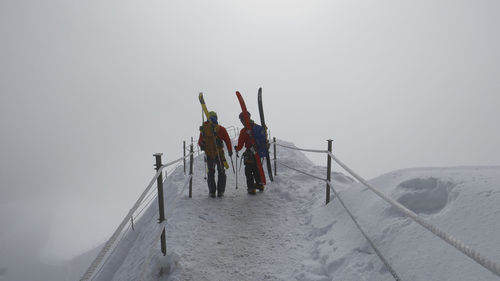 Rear view of people walking on snow at aiguille du midi mountain