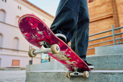 Low section of man holding skateboard