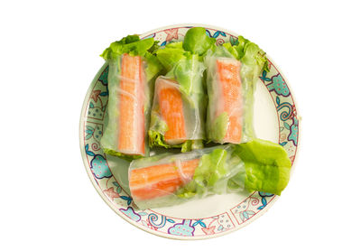 High angle view of chopped vegetables in plate against white background