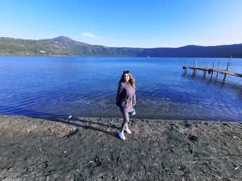 Woman standing on lake against sky