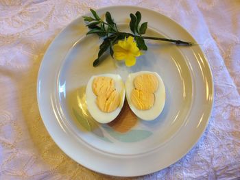 Directly above shot of boiled eggs with flower in plate 