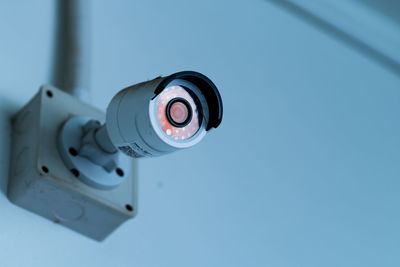 Low angle view of electric lamp against blue sky