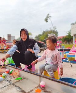 Mother and daughter fishing at fun fair