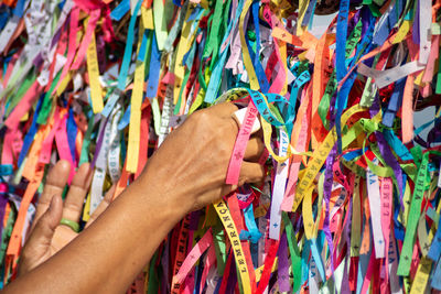 Severed hand of a person holding souvenir ribbons