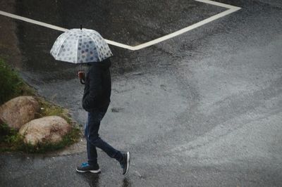 Low section of man walking on road