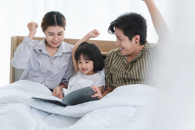 High angle view of friends on bed at home