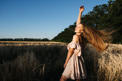 Woman standing on field against sky