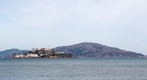 Scenic view of sea by buildings against sky