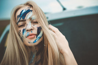 Portrait of beautiful young woman with painted face