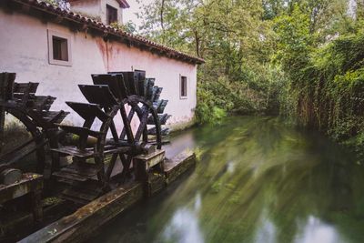 Watermill by river in forest